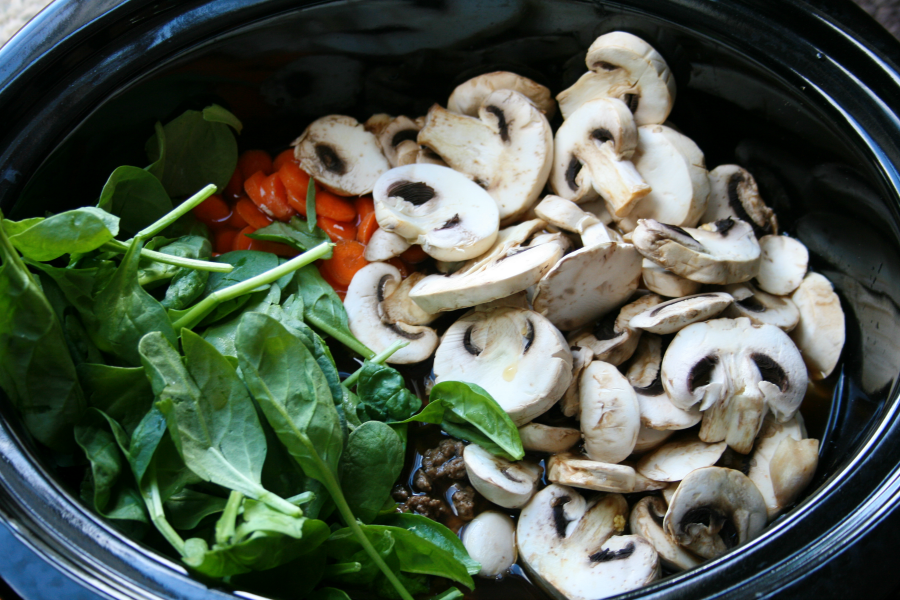 Creamy Crockpot Tortellini Soup ingredients inside a slow cooker