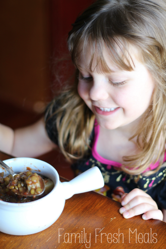 child eating a bowl of lentil soup