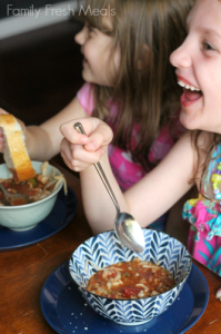 Two children sitting at a table eating Crockpot Stuffed Pepper Soup