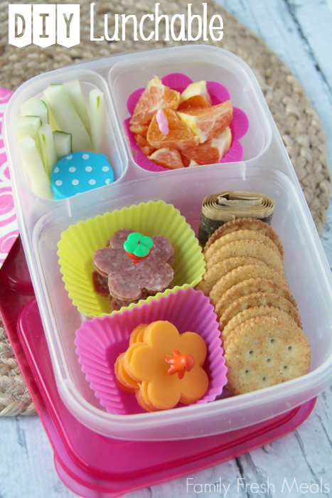 lunch meat and cheese flowers, crackers, fruit leather, oranges, cucumbers and a container of dip. Packed in a lunchbox