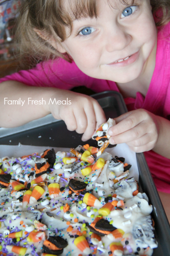 child holding a piece of Halloween Bark 