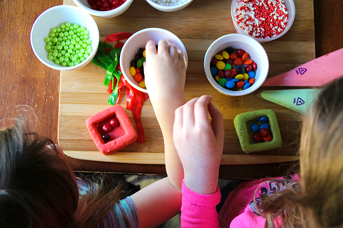top down image of two children filling present cookings with a variety of candies