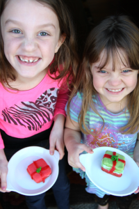 2 children holding plates with holiday cookies
