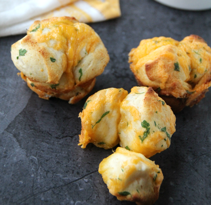 Three Cheesy Pull Apart Rolls on a black platter