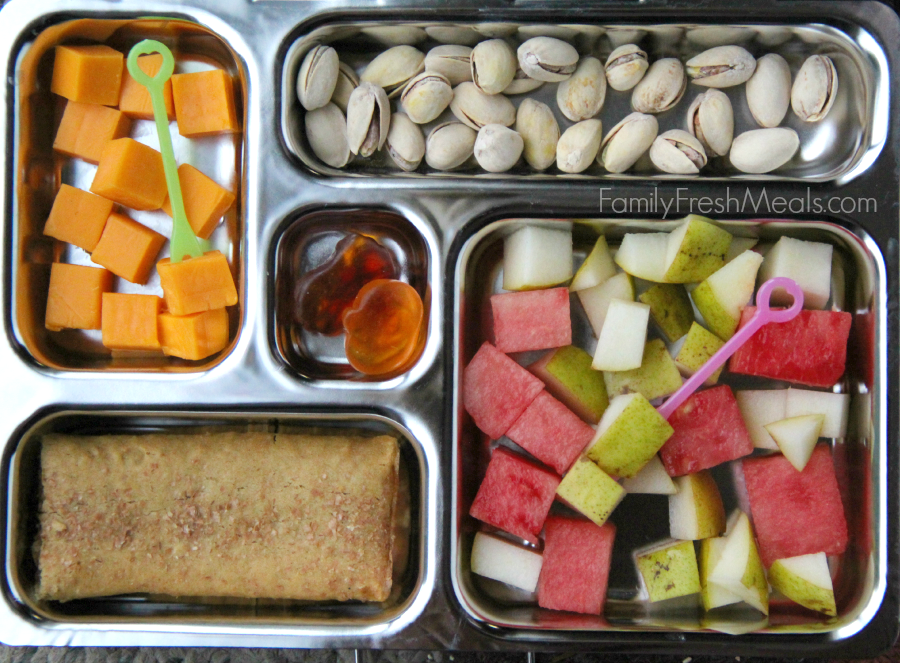 PlanetBox packed with pistachios, cheese cubes, fresh watermelon and pears, breakfast bar and a couple gummy treats.