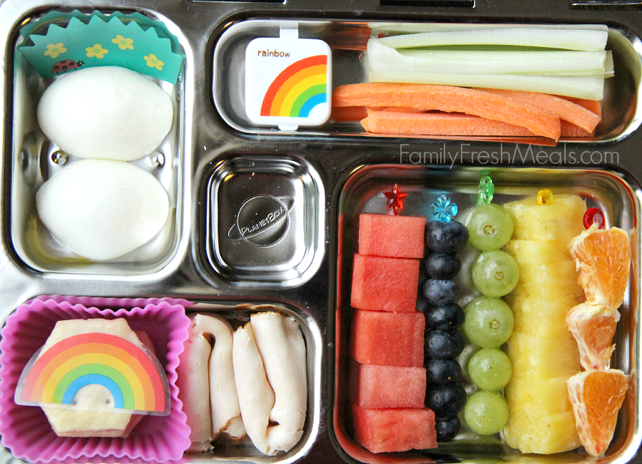 Planetbox lunch packed with celery, carrots and a small container of dip, hard boiled eggs, some lunch meat and crackers and fresh fruit.