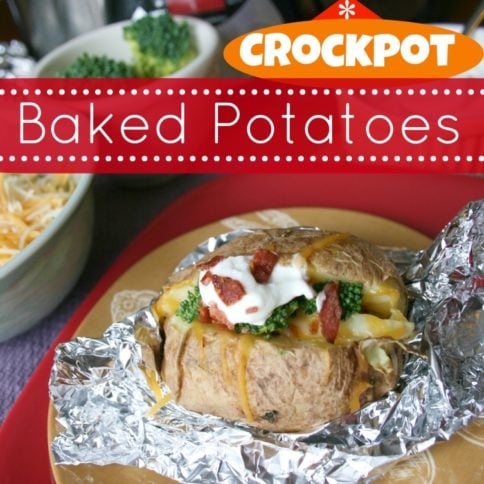 Crockpot Baked Potatoes, toped with bacon, broccoli and sour cream, set on tin foil, on a brown plate