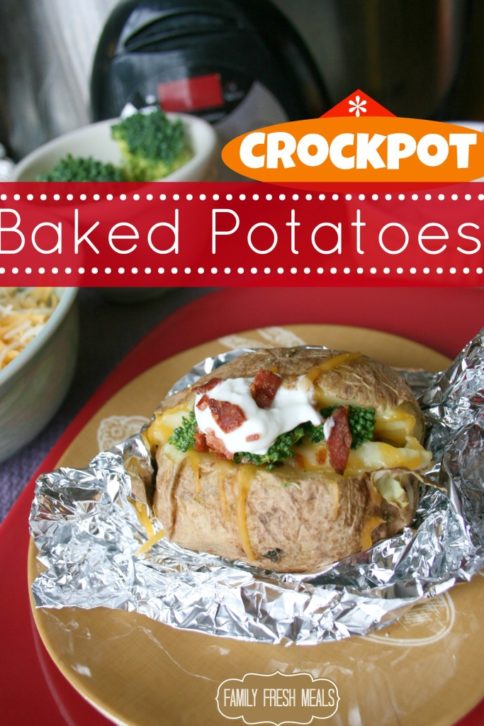 Crockpot Baked Potatoes, toped with bacon, broccoli and sour cream, set on tin foil, on a brown plate