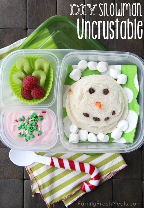 Uncrustable sandwich with carrot nose and raisin eyes/mouth,  mini marshmallow, a celery/raspberry wreath, and some Greek yogurt topped with food sprinkles. All packed in a lunchbox