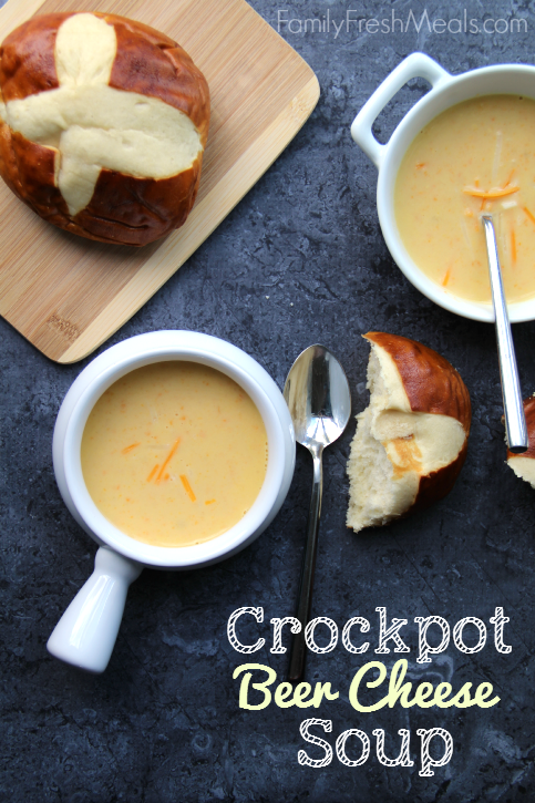 Two bowls of Crockpot Beer Cheese Soup in white bowls with pretzel rolls