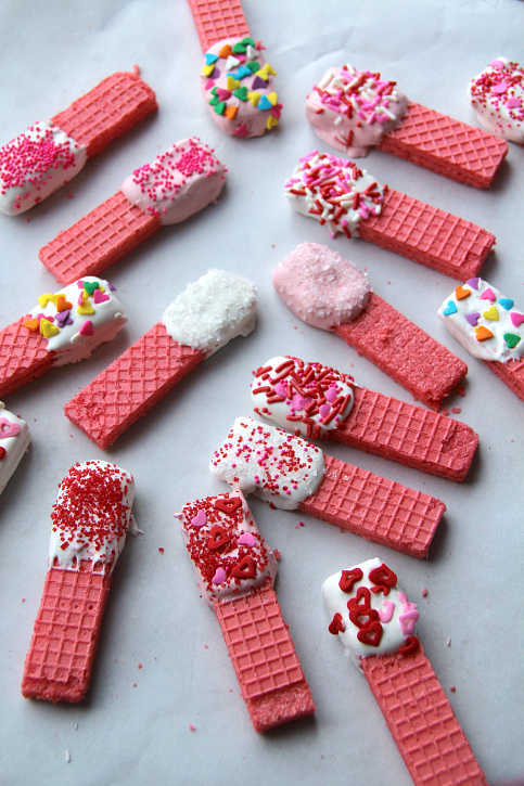 Valentine's Day wafer cookies laid out on parchment paper