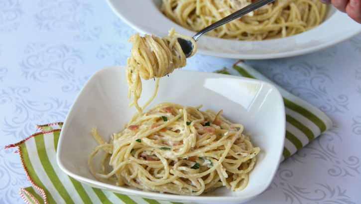 Slow Cooker Bacon Ranch Chicken served in a white bowl with a fork full of pasta