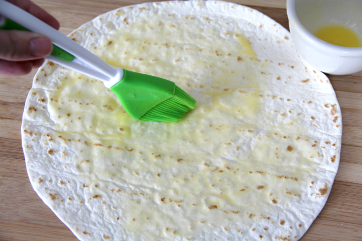 brushing tortilla with butter