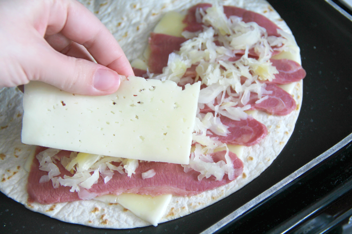 place a slice of cheese on top of corned beef and cabbage