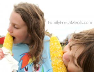 2 kids eating corn on the cob 