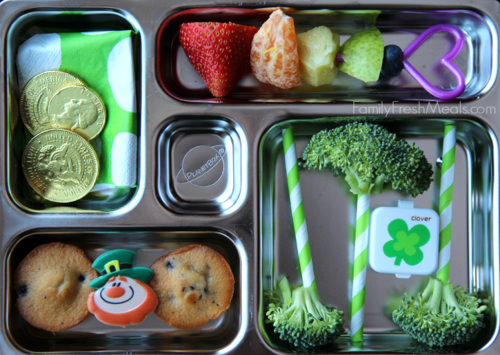 lunchbox packed with mini muffins, a skewer of rainbow fruit and broccoli