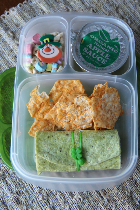 Lunch box packed with a Green Veggie Wrap, chips, apple sauce and cereal