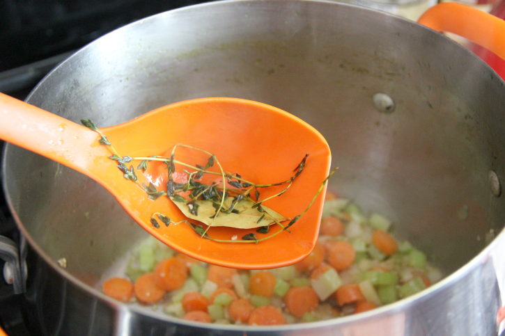 soup ladle removing herbs from pot