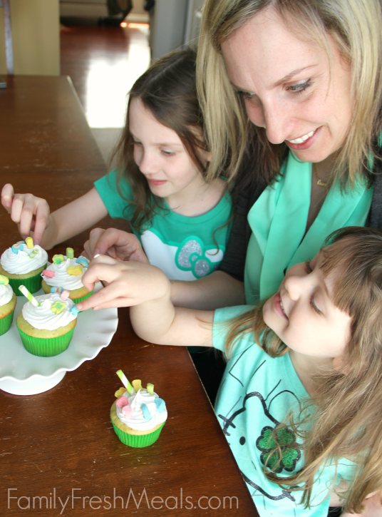 Woman and two children sitting in front of some Shamrock Shake Cupcakes