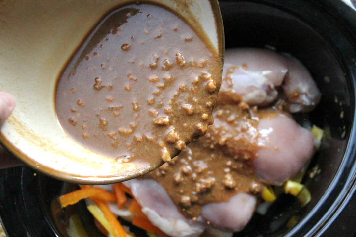 peanut sauce being poured into slow cooker