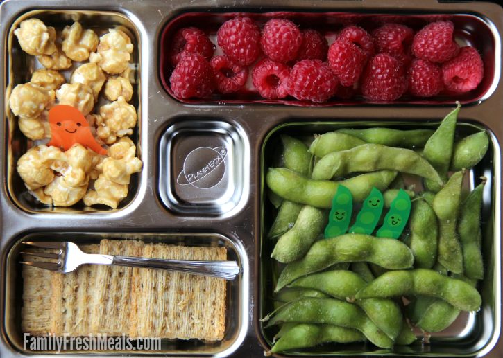 Edamame, crackers and fruit packed in a metal lunch box