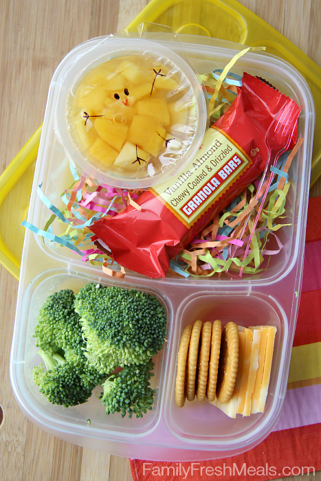 Fun Spring Fruit Cup Snack packed in a plastic lunch box with cheese, crackers, broccoli and granola bar