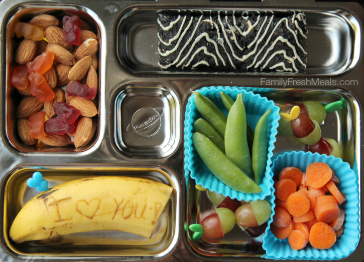 A Cliff Zbar, banana, grapes, carrots and snap peas, packed in a metal lunch box