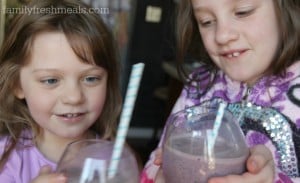 Two children holding cups of Blueberry Oatmeal Super Smoothie