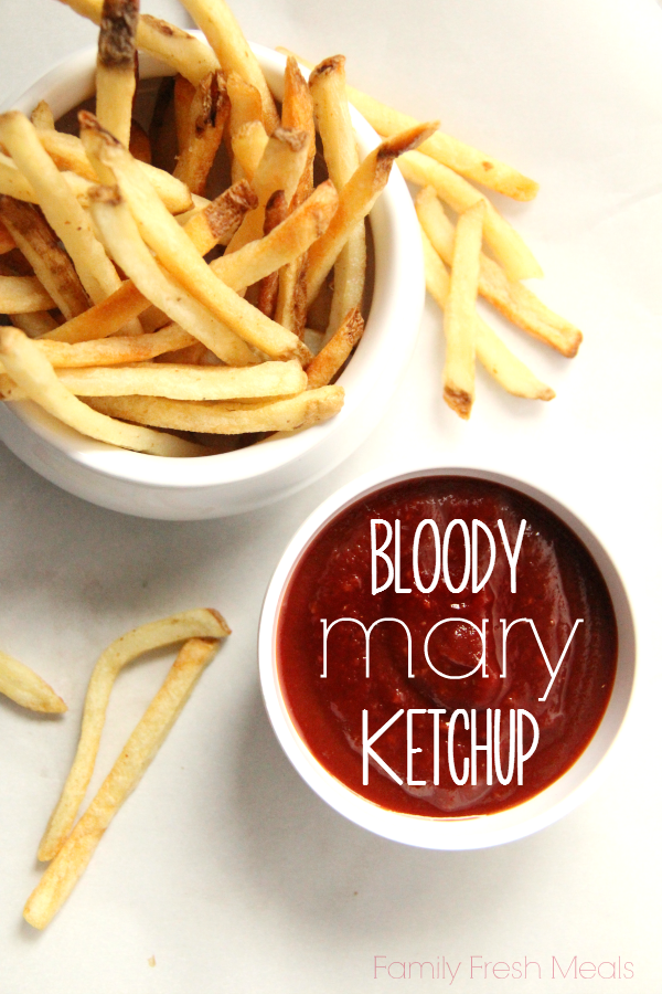 ketchup in a small bowl with with a bowl of fries