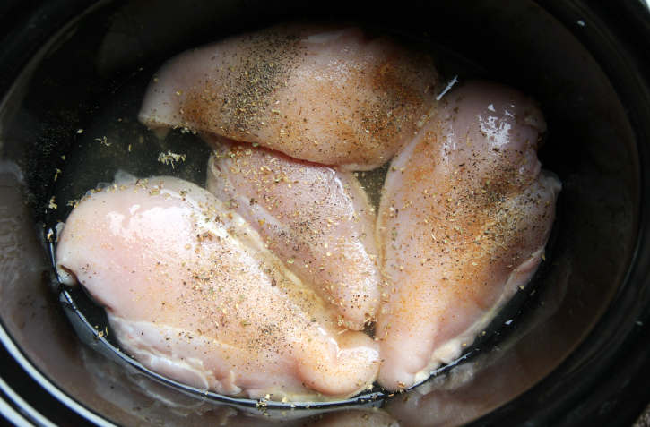 4 chicken breasts in a slow cooker with seasonings