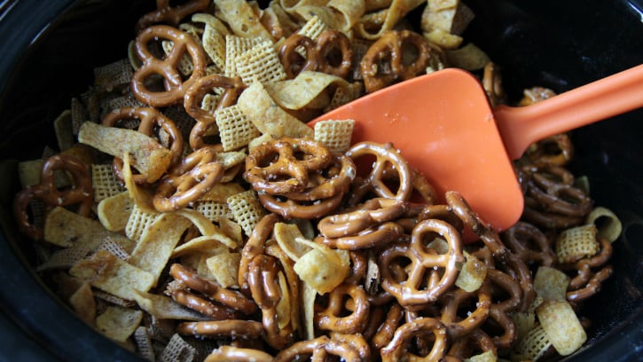 spatula mixing chex mix in a slow cooker