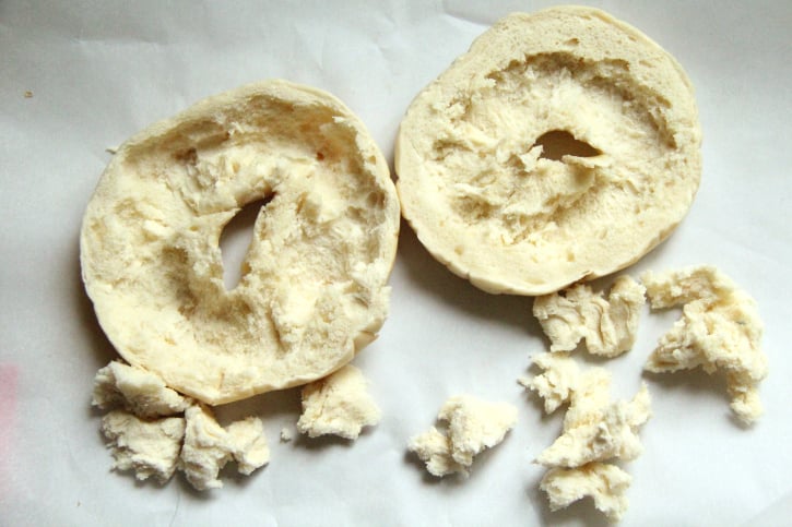 bagel cut in half with some pieces ripped out