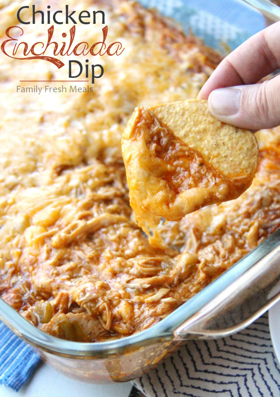 Scooping up Cheesy Chicken Enchilada Dip with a tortilla chip
