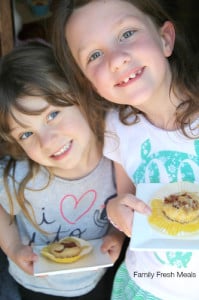 2 children holding plates with Baked Pancake Muffins on it