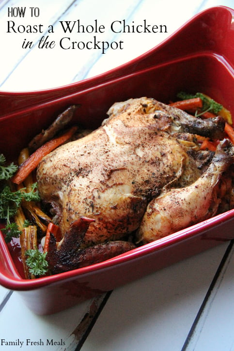 Roasted chicken with vegetables in a red serving dish