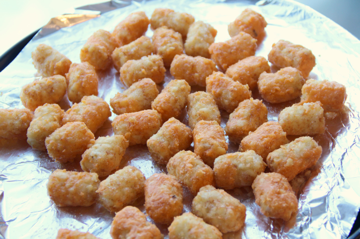 tater tots laid out on a foil lined baking sheet