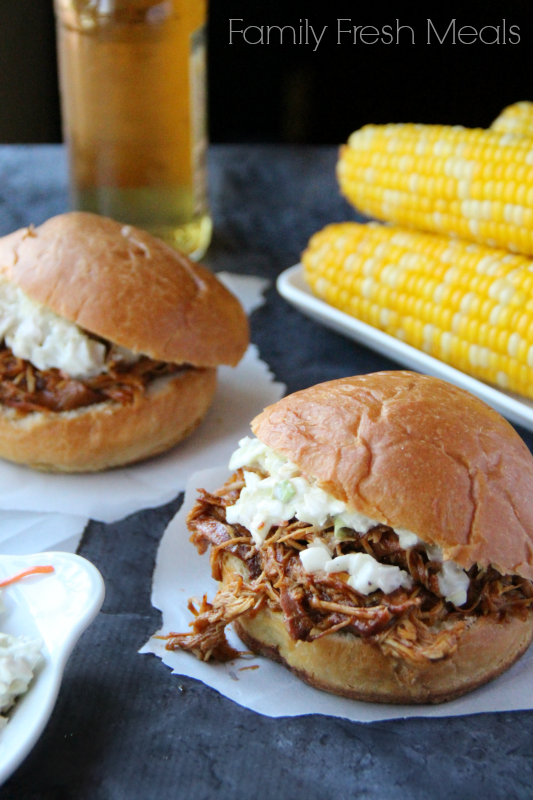 Two BBQ Chicken sandwiches with a side of corn on the cob