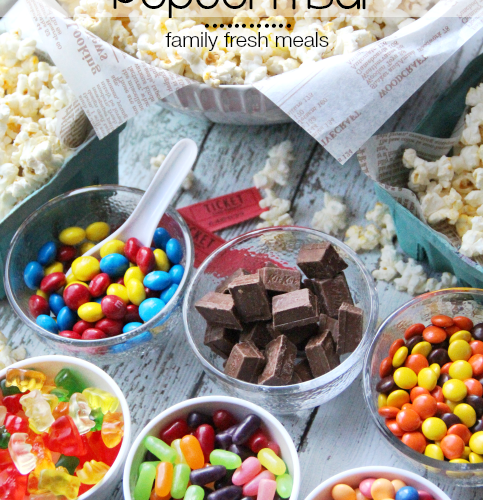 Large bowl of Popcorn surrounded by small bowls of different candies