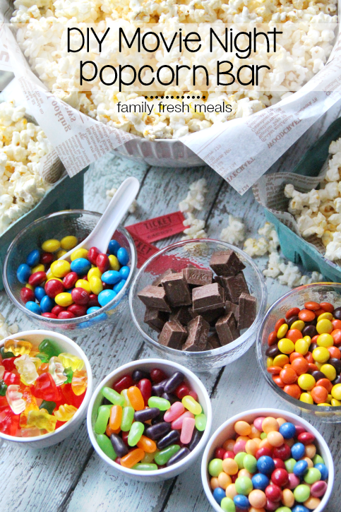 Large bowl of Popcorn surrounded by small bowls of different candies