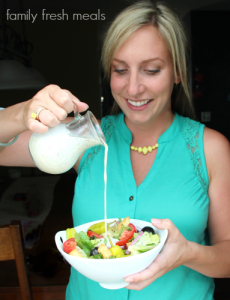 woman pouring dressing over a salad