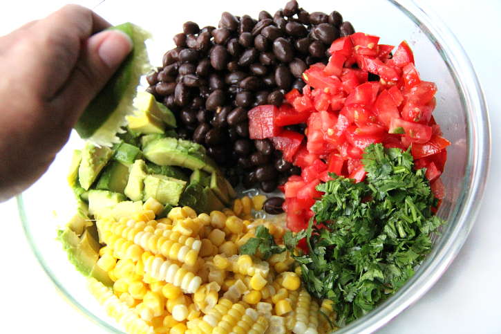 squeezing a lime over cowboy caviar ingredients 