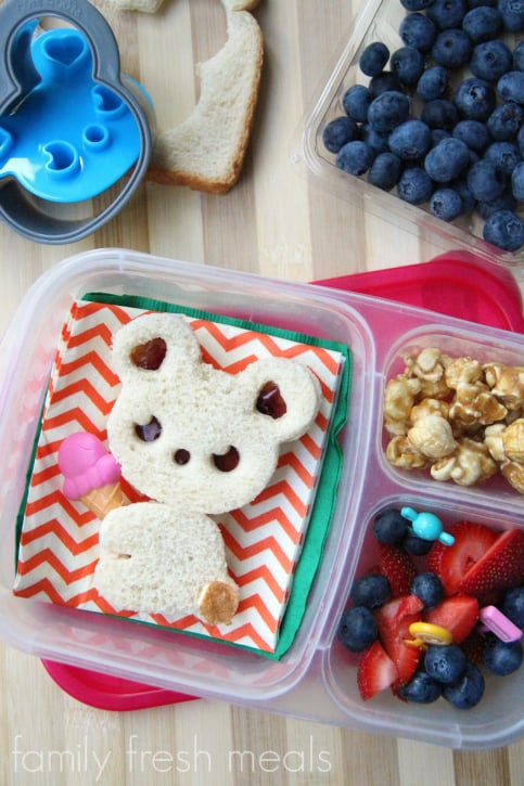 Bear shaped peanut butter and jelly sandwich, caramel corn and some fresh blueberries and strawberries.  Packed in a Lunchbox