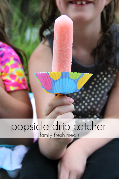 Child holding a popsicle with a cupcake liner on the stick