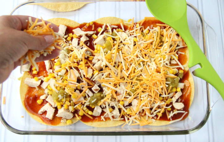 tortillas Topped with chicken , shredded cheese corn and enchilada sauce