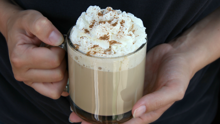 Hands holding a cup of Pumpkin Latte Coffee