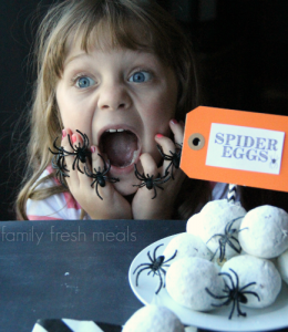 Child pretending to scream at donut holes and fake spiders