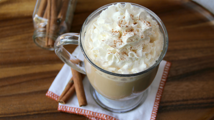 Glass mug full of Slow-Cooker Pumpkin Latte - topped with whipped cream