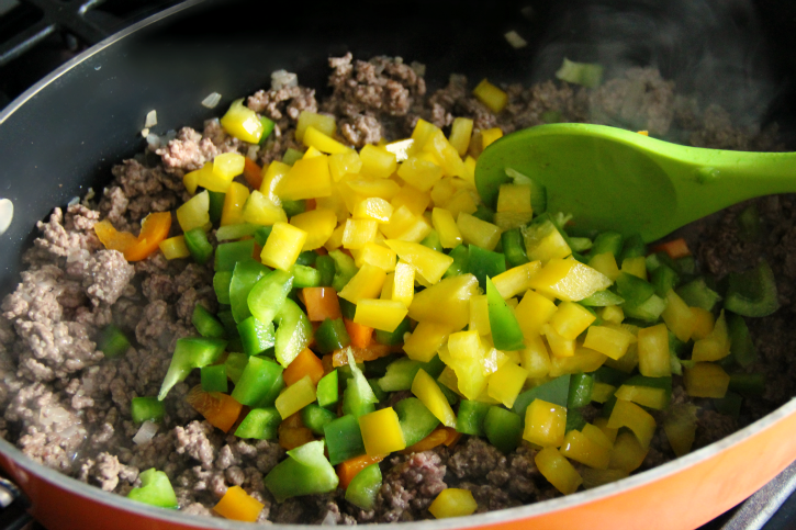 ground beef and diced peppers in a pan