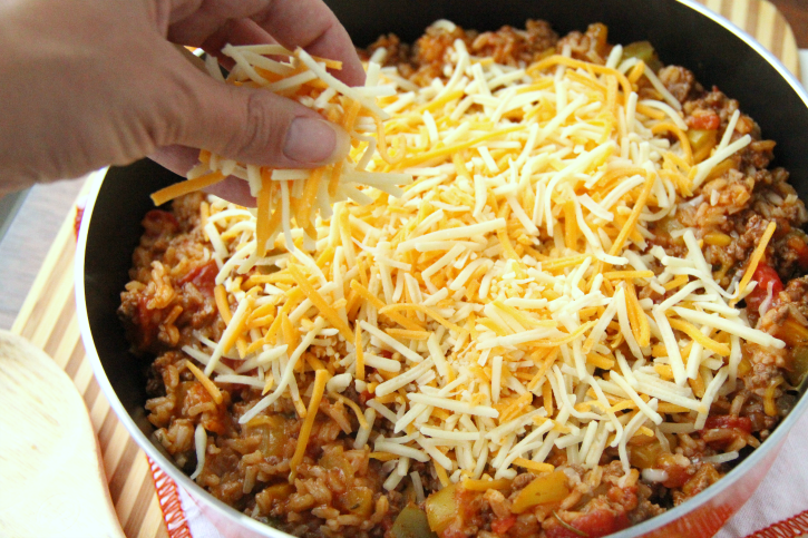 Adding shredded cheese to top of beef mixture