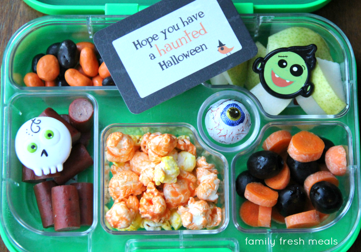 Yogurt raisins, turkey jerky, kettle corn, pears, carrot/black olive mix and a chocolate eye packed in a lunchbox